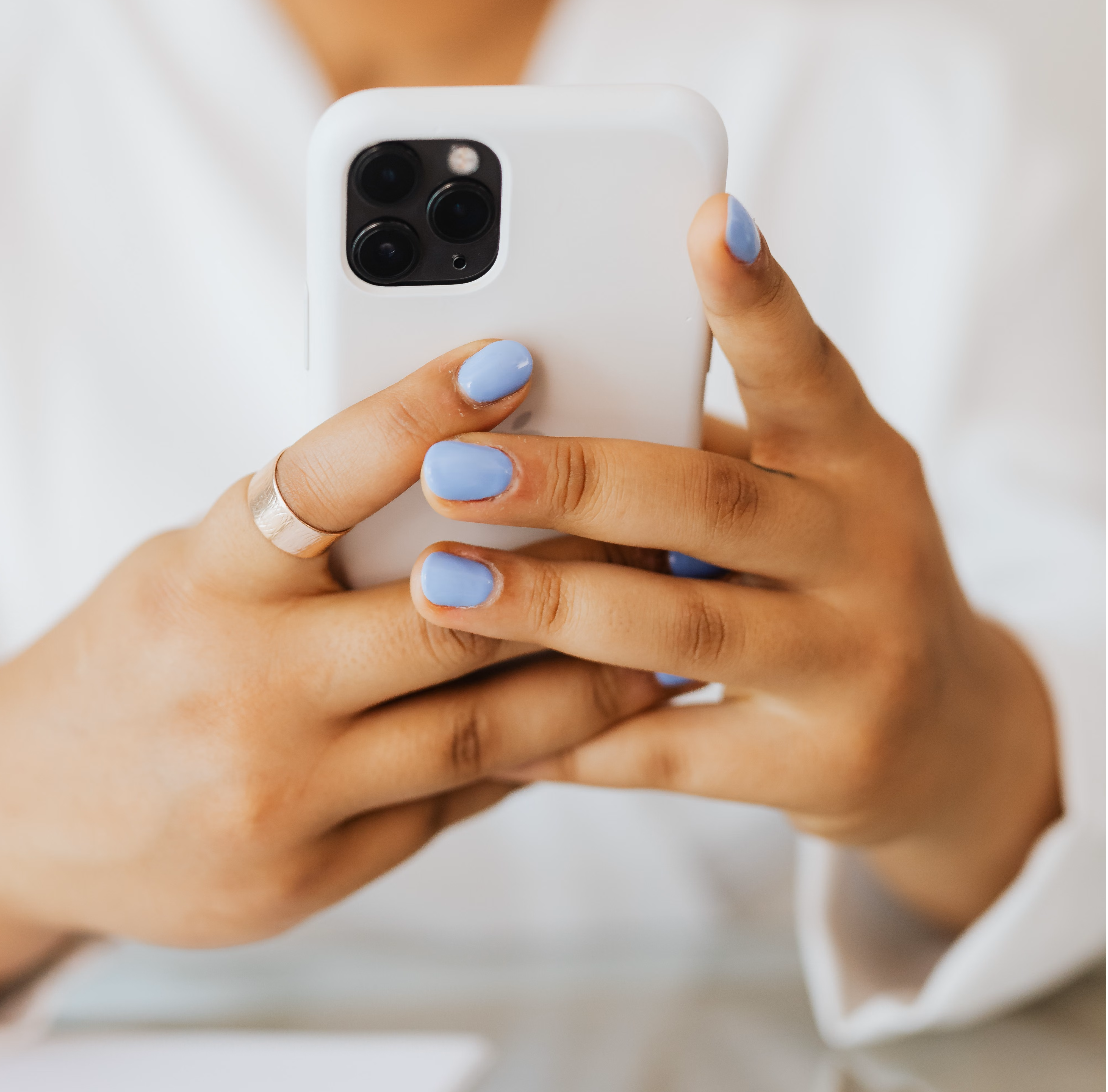 Close-up of two hands holding a phone with its camera facing out, ready to take a photo